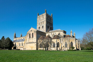 Fototapeta na wymiar A low wide angle image of Tewkesbury Abbey with the beautiful green grass foreground and clear blue skies.