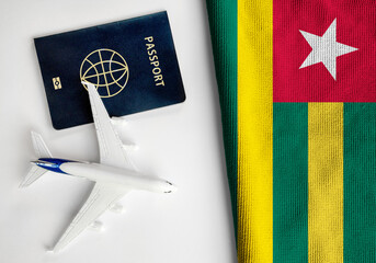 Flag of Togo with passport and toy airplane. Flight travel concept 