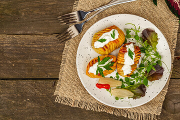 Baked accordion potatoes with fresh greens mix, fermented vegetables, and pea sprouts