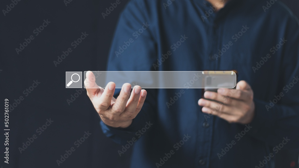 Wall mural the concept of using technology to search for information, a man's hand is using a smartphone to sea