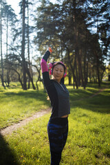 Woman runner stretching arms before exercising summer park morning.  female warming up body before running asian person warm up jogging 
