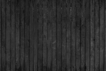 Vintage fence of old wooden boards. Texture of an aging wooden surface. Beautiful wooden background.