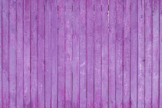 Vintage fence of old wooden boards. Texture of an aging wooden surface. Beautiful wooden background.