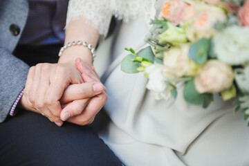 Obraz na płótnie Canvas Closeup shot of a bridegroom holding bride's hand. Wedding ring. Tenderness concept