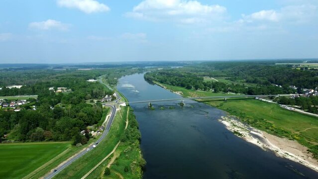 Vue a&eacute;rienne d'un fleuve avec un pont et une route parall&egrave;le