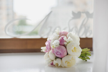 Wedding white flower bouquet for a bride on window background.