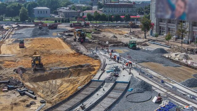 Work bulldozers and excavators on the construction site of a road timelapse. Crushed stone on substrate. Support activities and industrial machinery. Reconstruction of tram tracks. Aerial top view