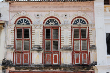 Obraz premium Beautiful arched windows on the exterior facade of an old building in the heritage town of Penang.