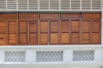 Detail of brown rectangular wooden windows of an old vintage shop house in the heritage town of Penang.