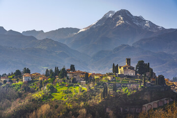 Barga town and Alpi Apuane mountains in winter. Garfagnana, Tuscany, Italy. - obrazy, fototapety, plakaty