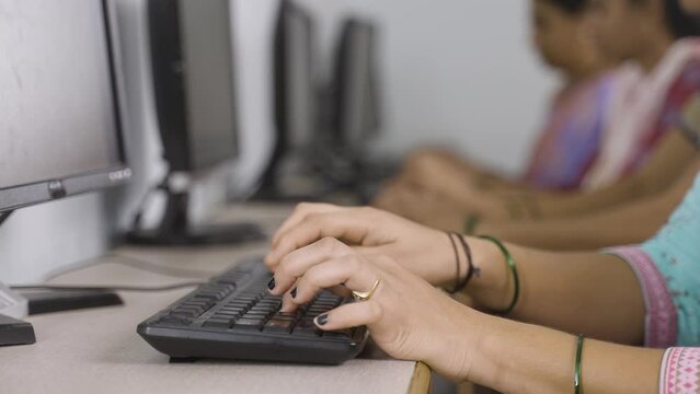 close up shot of group of women hads busy learning or working on computer at training center by typing - concept of empowerment, learning and education