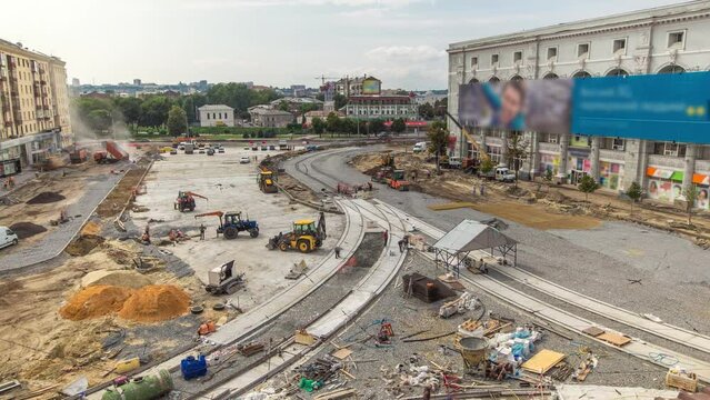 Work tracktors and excavators on the construction site of a road timelapse. Crushed stone on substrate. Support activities and industrial machinery. Reconstruction of tram tracks. Aerial top view from