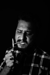 Smoker lighting cigarette over black background