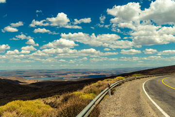 panoramic from the route with a desert landscape and a lake in the background and blue sky