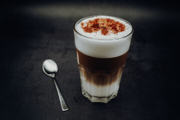 Glass of latte macchiato with spoon