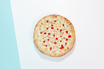 Italian pizza with chicken and paprika on coloured background. Cheese pizza with chicken and corn in minimal style on blue and purple color. American pizza delivery concept with color backdrop