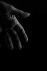 Close up view in black and white of an open hand on white background, sign of help and welcome, with space for text