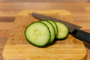 cut cucumber on a wooden board with knife