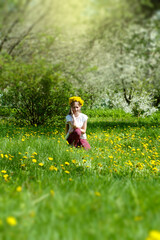 Fototapeta premium Girl in a wreath of yellow dandelions. Spring. Dandelions.