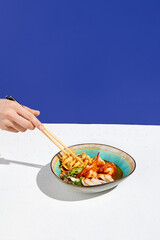 Traditional asian soup with seafood and udon noodle in ceramic bowl. Japanese soup with udon,...