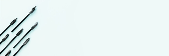 Set of brushes for eyelashes and eyebrows on blue background. Correction and care. Cooling and laying. Womens cosmetics. Banner.