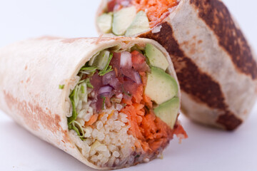 Burrito with avocado slices, bean paste, mexican rice, salsa, green salad, grated carrots