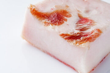 piece of lard on a white acrylic background
