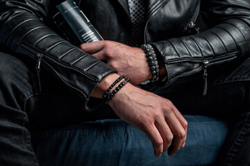Fototapeta na wymiar Men's bracelets on the hands. Business attire, leather jacket and magazine