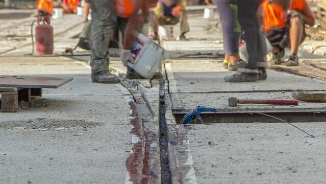 Tram rail at the final stage of integration into concrete plates on the road timelapse. Filling by liquid resin for reduction of vibration and noice. The process of reconstruction of tram tracks.