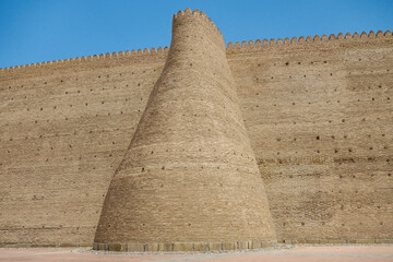 Fototapeta na wymiar Walls of Ark, an ancient fortress in Bukhara, Uzbekistan. The height of the walls reaches 20 m. The fortress was founded in the 5th century and is now included in UNESCO