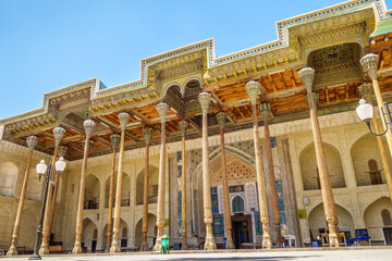 Street colonnade of the Bolo-Haouz mosque: painted wooden ceilings and carved columns. Shot in Bukhara, Uzbekistan - obrazy, fototapety, plakaty