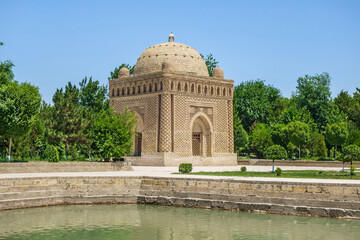 Samanids mausoleum building (built in beginning of X century) and the traditional urban pool (so called houz) in the park. Shot in Bukhara, Uzbekistan - obrazy, fototapety, plakaty