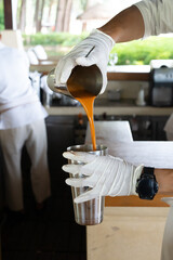 One process of making traditional Thai iced tea is to pour the tea back and forth. The reason to do...