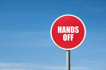 'Hands off' sign in red round frame. Clear blue sky is on background