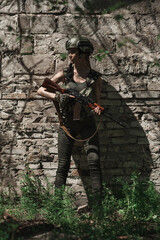 Fototapeta premium Military girl in uniform near a stone wall during the day