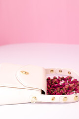fashion photo of purse. white woman handbag near little roses flowers. isolated on white and pink background. Product composition photography