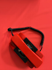 Red telephone on a red background with copy space. Direct telephone line of communication between...