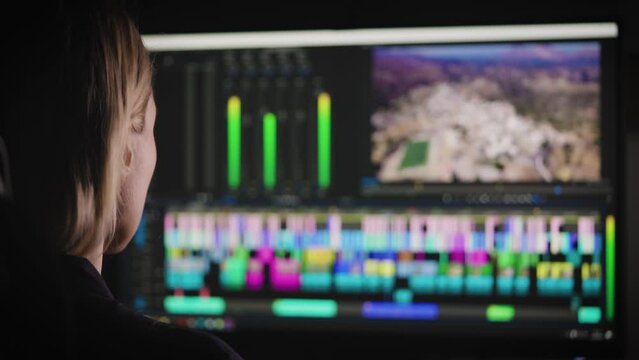 A woman is doing video editing at her home studio. The process of creating video content