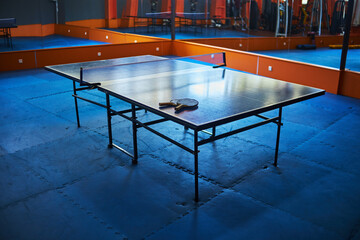 table with table tennis rackets in the gym. selective focus, low depth of focus. a small grain for...