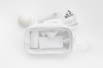 Fototapeta na wymiar Cosmetic bag full of white cosmetic products and accessories, top view