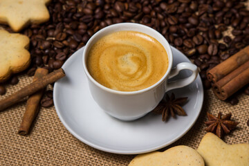 Espresso coffee on the background of coffee beans. A cup of coffee with cinnamon. invigorating drink