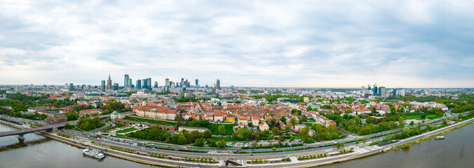 Historyczna panorama miasta z widokiem pod dużym kątem na kolorowe dachy budynków na rynku starego miasta. W tle widok na centrum nowoczesnej Warszawy z sylwetkami drapaczy chmur. - obrazy, fototapety, plakaty
