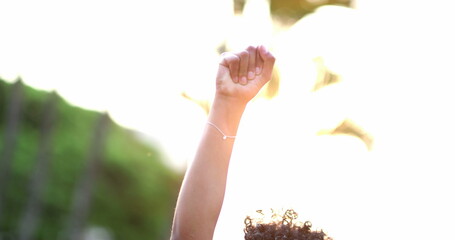 Fototapeta African American woman raises fist in air in political movement, black person activist obraz