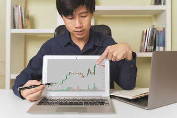 Businessman, investor teaching, pointing on stock or Cryptocurrency trading graphs to teach about...