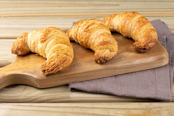 Triple croissant on cutting board. Selective focus.
