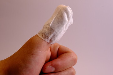 close up of injured thumb with bandage.