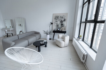 modern minimalistic interior design of light bright monochrome room with black and white furniture, clean white walls and huge windows