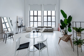 modern minimalistic interior design of light bright monochrome room with black and white furniture, clean white walls and huge windows