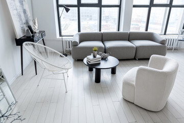 Fototapeta premium modern minimalistic interior design of light bright monochrome room with black and white furniture, clean white walls and huge windows