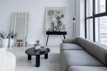 modern minimalistic interior design of light bright monochrome room with black and white furniture, clean white walls and huge windows